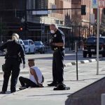 A Car Jumped The Curb At The White House — Then He Made One DEMAND Police officers detain a seated man on a city sidewalk