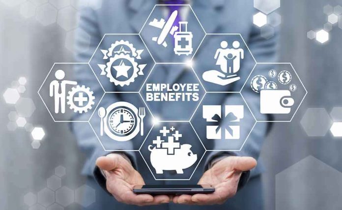 shutterstock_1732651994 Businessperson holding icons of employee benefits above a smartphone