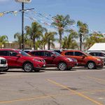 Every Car On The Lot Had A HIDDEN Cost — Until NOW Row of new cars on a dealership lot under pennant flags