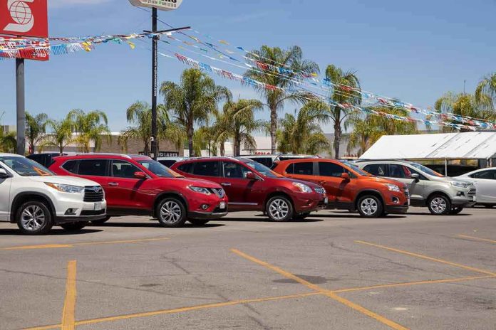 Row of new cars on a dealership lot under pennant flags