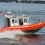Coast Guard patrol boat speeding across a bay