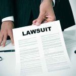WHISTLEBLOWER Sues California — About TIME Businessperson holding a lawsuit document at a desk