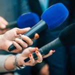 Socialist UPSET Jolts Deep-Red Florida Reporters holding colorful microphones