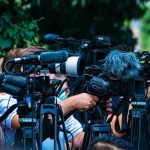 Fake Resignation Explodes — Who Runs Iran? TV news cameras crowding together at an outdoor event