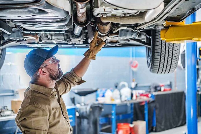 Mechanic inspecting underside of a car on a lift