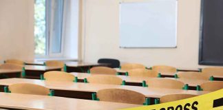 Empty classroom with police tape across desks