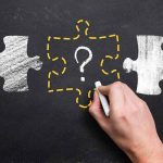 hand drawing puzzle piece with question mark on chalkboard