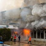 firefighters respond to large building fire with heavy smoke