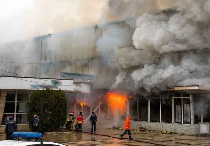 shutterstock_404947000 firefighters respond to large building fire with heavy smoke