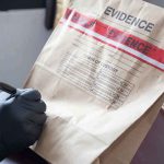Judge Throws Out Backpack Search — Shocking Ruling! Gloved hands labeling a sealed evidence bag