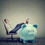 Why Trump’s Kid Account Is BETTER Than Passbook Savings Woman relaxing in chair with feet on giant blue piggy bank