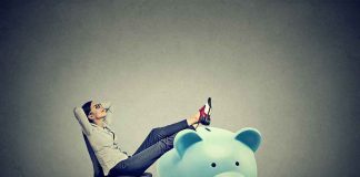 Why Trump’s Kid Account Is BETTER Than Passbook Savings Woman relaxing in chair with feet on giant blue piggy bank