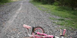 JUDGES Just Took 20,000 Off The Predator List — Victims Had NO Say Pink children's bicycle with training wheels lying on a gravel path