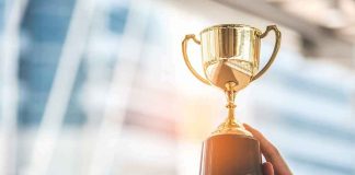 This Senior Citizen Beat The World — For The THIRD Time Hands holding a golden trophy cup