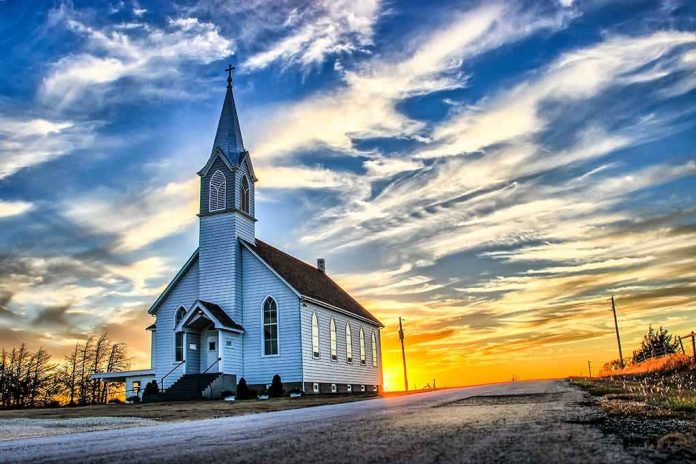 shutterstock_1186359178 White country church with steeple at sunset