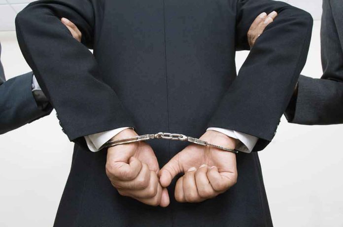 shutterstock_121141399 person in a suit with hands cuffed behind back