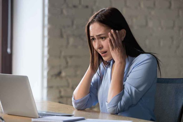 shutterstock_1256570839 Concerned woman looking at laptop with hands on her head