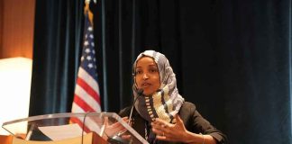 Ilhan Omar speaking at a podium with a microphone