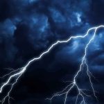 Lightning bolts streak across dark storm clouds