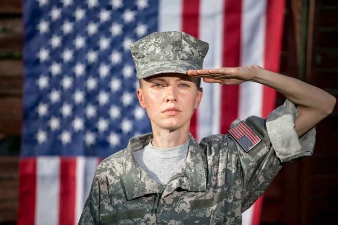 shutterstock_1416735905 soldier in camouflage uniform saluting in front of a U.S. flag