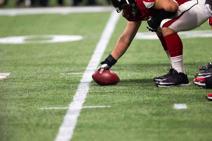 shutterstock_1481117636 football player setting the ball on the line of scrimmage