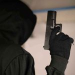 Highway Shootout STUNS Small Town Hooded person holding a handgun