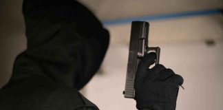 Highway Shootout STUNS Small Town Hooded person holding a handgun