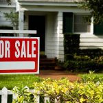 For sale sign in front of a suburban house