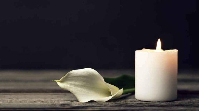 shutterstock_1658063071 White candle and calla lily on wooden surface