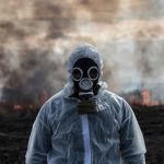Families FLED In The Night — What The Fog Was HIDING Person in hazmat suit wearing gas mask amid smoke