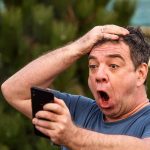 ALARMED Residents WARNED City Leaders — Guess WHAT Moved In Exasperated man pressing a hand to his forehead while reading his phone