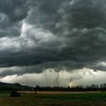 Dark storm clouds over a rural field