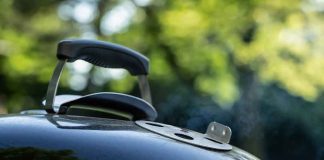 Close-up of a charcoal grill lid with handle and vent