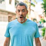 Man with surprised expression on a sunny street