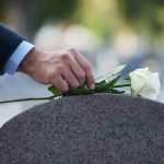 Country Legend Dead — The Timing Is Almost Too CRUEL hand placing white rose on gravestone