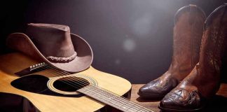Rodeo Night Turns Deadly Acoustic guitar with cowboy hat and leather boots on wooden table