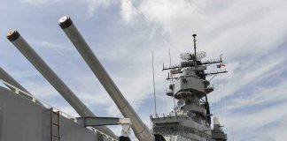 Old Warships FOOLED An Army — Where The REAL Attack Came From Close-up of a battleship's big naval guns and superstructure against a cloudy sky
