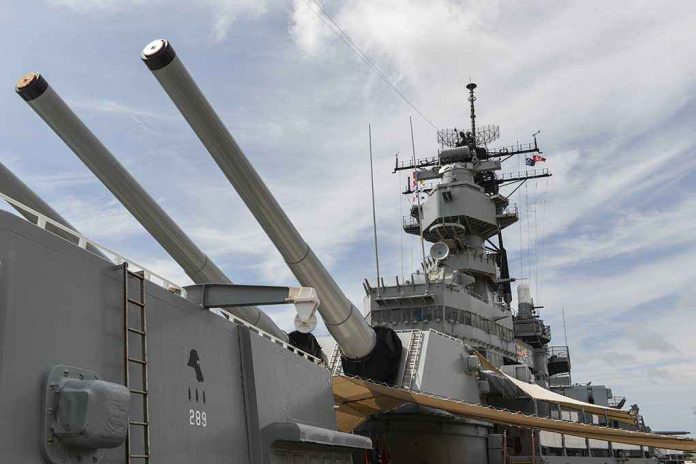shutterstock_224332015 Close-up of a battleship's big naval guns and superstructure against a cloudy sky
