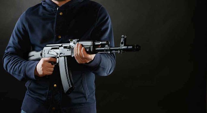 shutterstock_268262531 person holding a rifle against a dark background