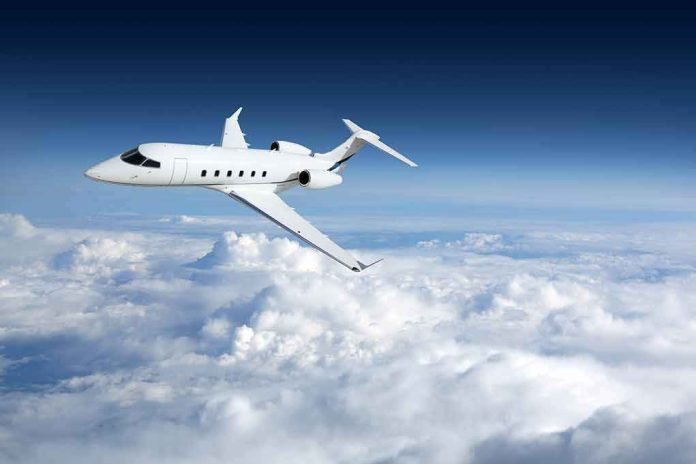 shutterstock_758054764-1 Private jet flying above clouds