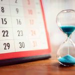 Sharp 84-Year-Old’s PERFECT Timing Saved Him A FORTUNE Hourglass with blue sand beside a desk calendar